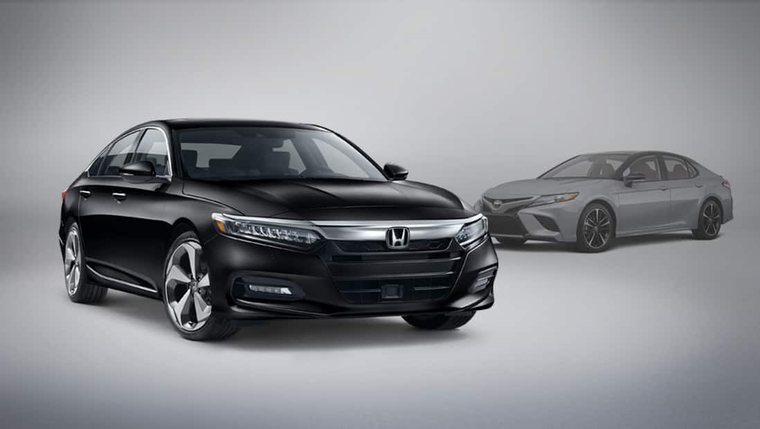 Front passenger-side view of the 2020 Honda Accord Touring 2.0T parked next to competitor vehicle Toyota Camry.
