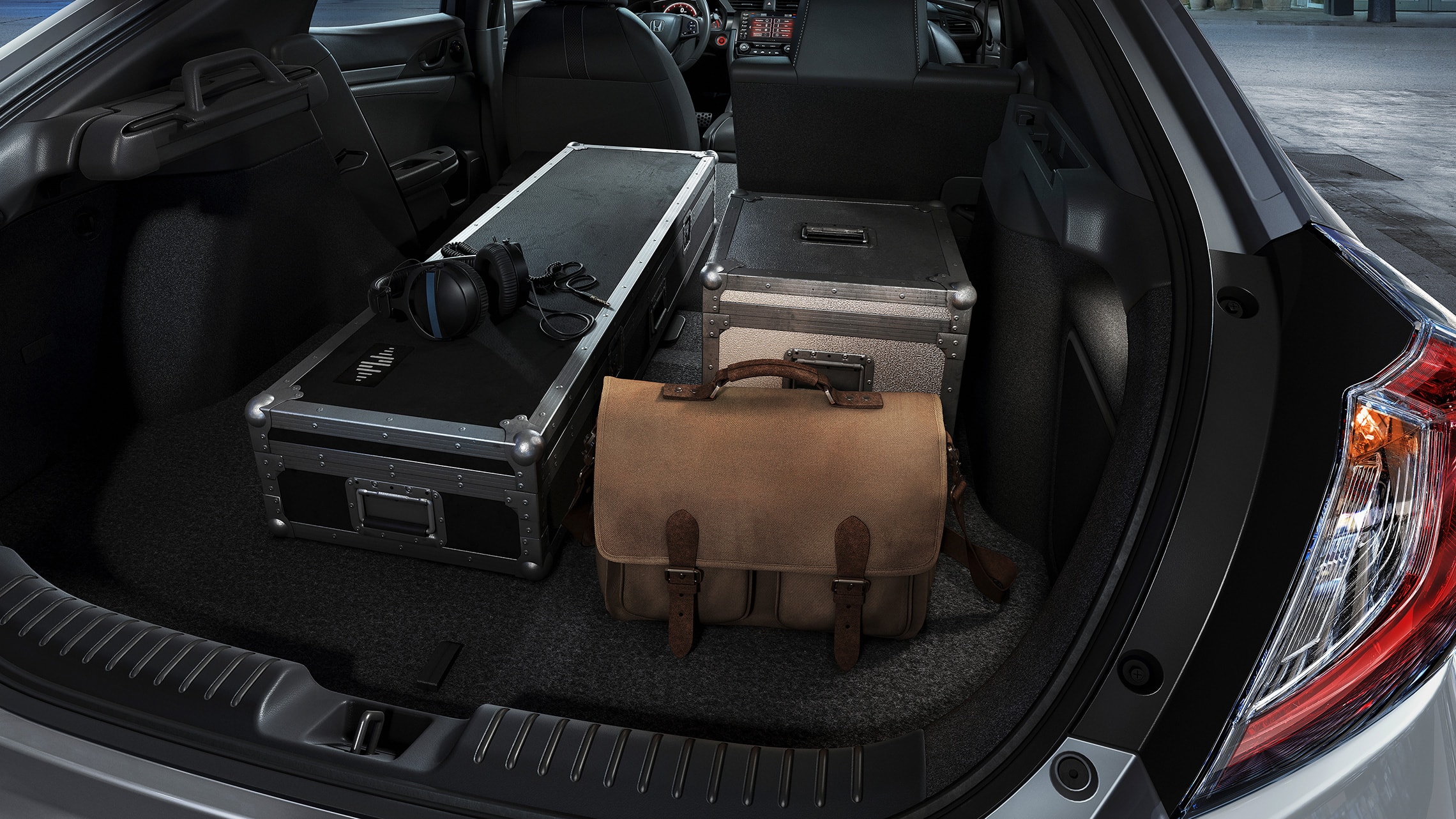 Varios artículos cargados en el espacio de carga del Honda Civic Sport Touring Hatchback 2021 con asientos traseros divididos y plegables 60/40.
