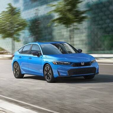2027 Honda Civic Hatchback Sport Touring Hybrid in Boost Blue Pearl profile driving on a city street (Compact Hatchback).